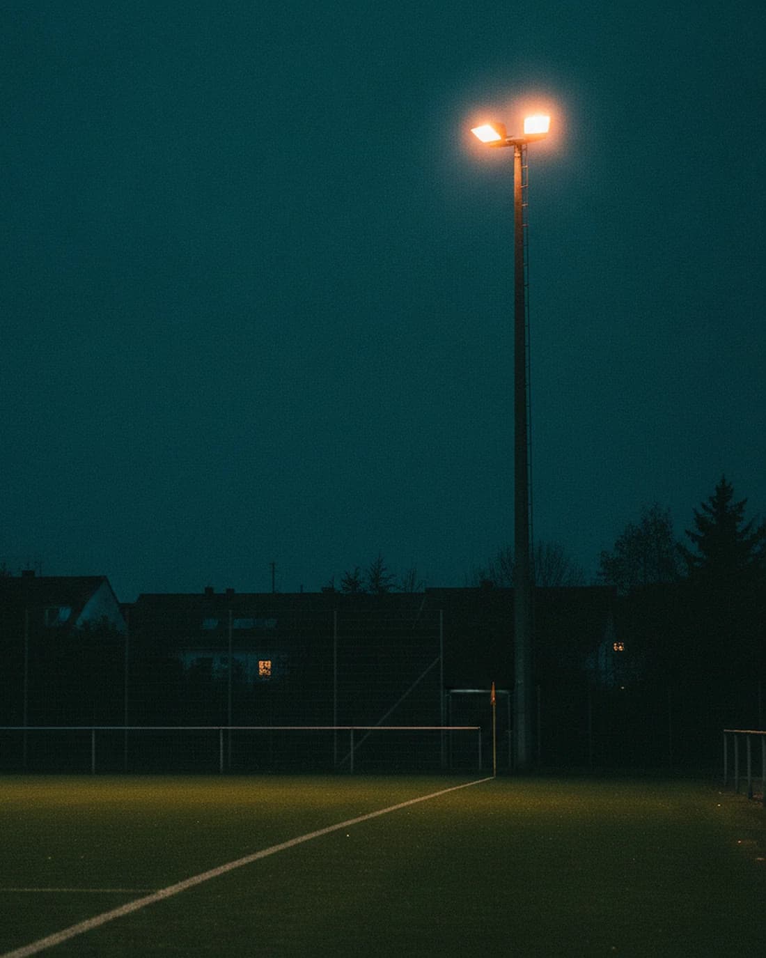 Die Sportanlage Brühlwiese in der blauen Stunde, Flutlichtmast über dem Naturrasen